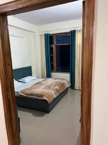 1 dormitorio con cama y ventana en Ranas B&B, en Shimla