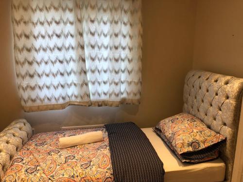 uma pequena cama num quarto com uma janela em Nice 3-Bed House in Farnham Royal Slough em Slough