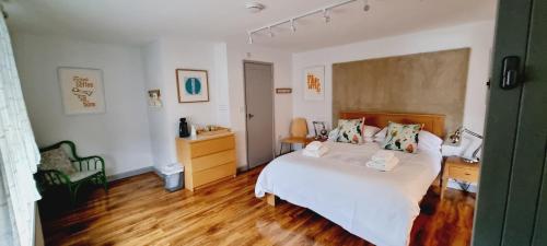 a bedroom with a white bed and wooden floors at B - Simply Rooms in Stow on the Wold