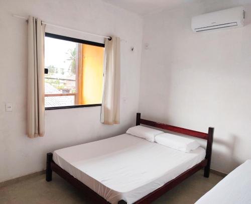 sypialnia z łóżkiem i oknem w obiekcie Casa do Sol Flecheiras w mieście Trairi