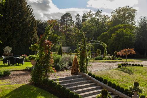 a garden with stairs and a table in the background at Oatlands Park Hotel in Weybridge