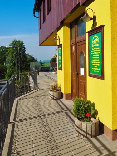 a yellow building with plants on the sidewalk at Penzion PANORAMA Janovičky in Broumov