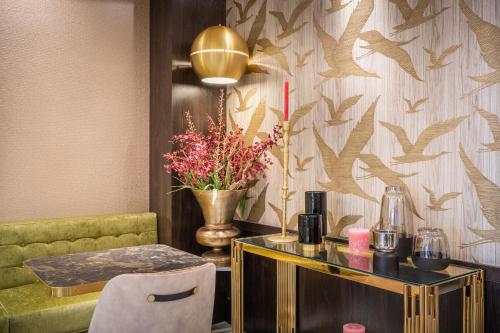 een kamer met een tafel en een vaas met bloemen bij Hotel Oscar in Amsterdam