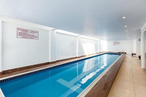 a large swimming pool in a building at Apartamento perfeito para descansar in Imbituba
