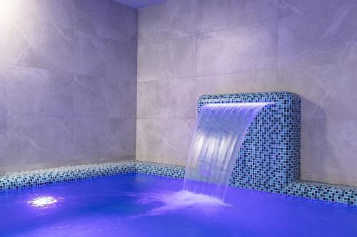 a swimming pool with a waterfall in a bathroom at Premium hotel & SPA in Bukovel