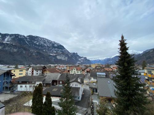 a town with houses and mountains in the background at Hotel Sherlock Holmes & Khana Restaurant "200 m Gondola to Hasliberg ski" in Meiringen