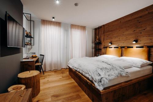 a bedroom with a large bed with a wooden headboard at JOHAN HOTEL in Zlín