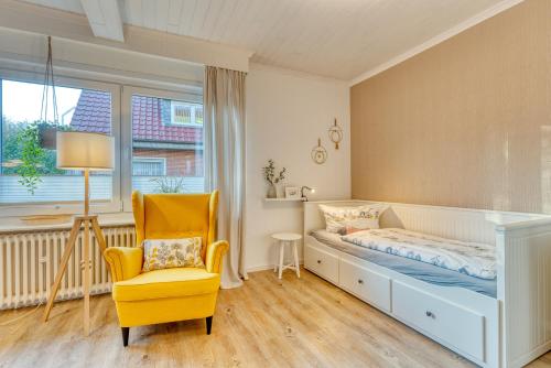 ein Schlafzimmer mit einem Bett, einem Stuhl und einem Fenster in der Unterkunft Vorderhuus in Norderney