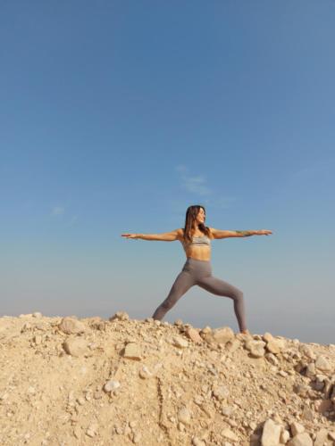 a woman standing on top of a pile of rocks at Badolina Ein Gedi Glamping in Ein Gedi