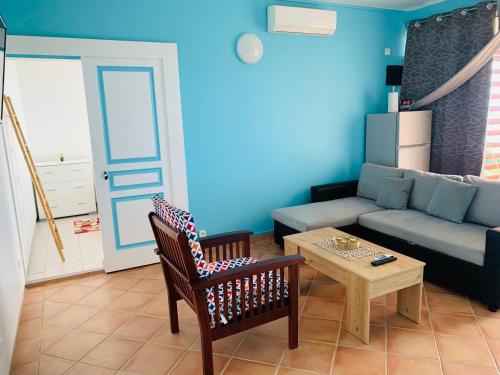 a living room with a couch and a table at PARADIS AU SOLEIL, vue panoramique sur mer in Bouillante