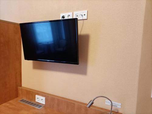 a flat screen tv hanging on a wall at Hotel An der Karlstadt in Bremerhaven