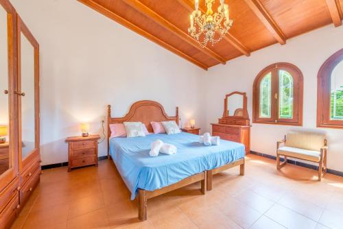 a bedroom with a bed and a chandelier at Finca Es Rafalot de Dalt by Mallorca House Rent in Manacor