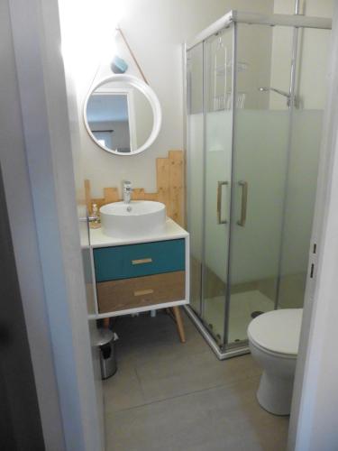 a bathroom with a sink and a toilet and a mirror at agréable maison de famille in Sigean