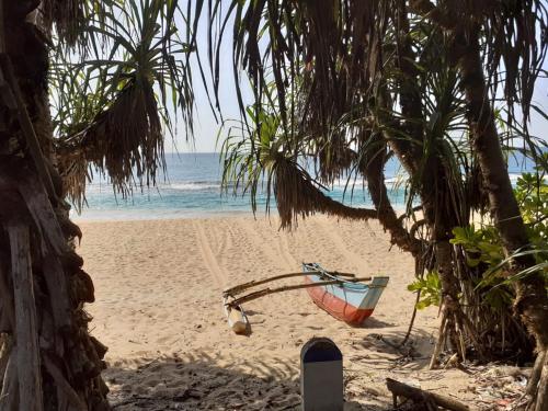 a boat sitting on a beach near the ocean at Turtle Paradise in Tangalle