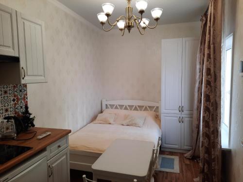 キスロヴォツクにあるGuest house on Lermontovaのベッドとシャンデリア付きの小さなベッドルーム1室