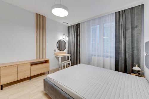 sypialnia z łóżkiem, biurkiem i lustrem w obiekcie Comfort Apartments Wilcza w Gdańsku