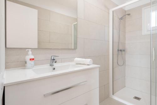 a white bathroom with a sink and a shower at Apartment Sa Caseta 1 by Mallorca House Rent in Portopetro