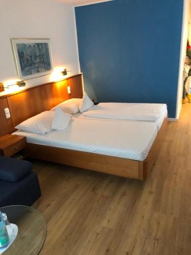 ein Schlafzimmer mit einem Bett und einer blauen Wand in der Unterkunft Seminar- und Urlaubshotel Schulz in Bergen