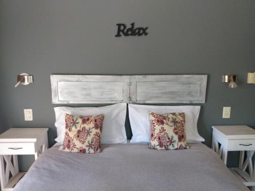 a bedroom with a large bed with two pillows at La Pausa Lodge de Campo in Duggan