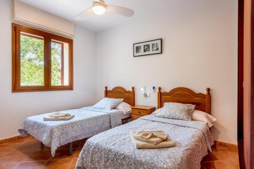 a bedroom with two beds with towels on them at Finca Alcina by Mallorca House Rent in Felanitx