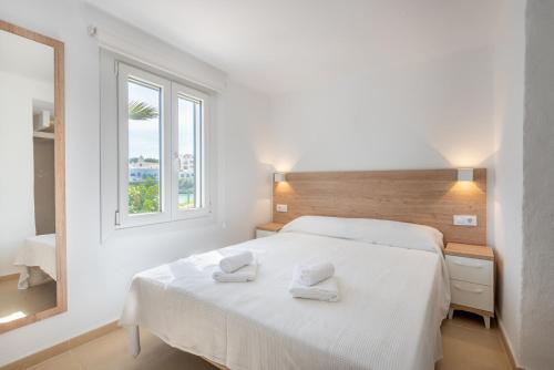 a bedroom with a white bed with two towels on it at Apartment Sa Caseta 3 by Mallorca House Rent in Portopetro