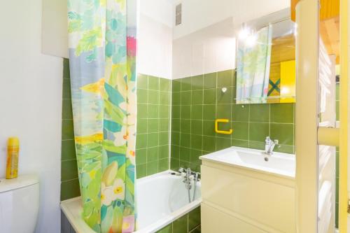 a bathroom with a sink and a shower curtain at L'Altitude - Appartement avec balcon au pied des pistes in Saint-Lary-Soulan