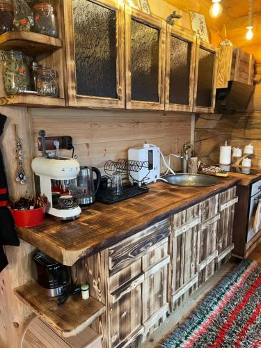 Una cocina con gabinetes de madera y encimera. en ECO HOUSES ART OF LIVING - Еко къщи изкуството да живееш, en Pamporovo