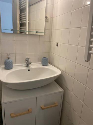 ein Badezimmer mit einem weißen Waschbecken und einem Spiegel in der Unterkunft Arcole 2-Studio Beziers Centre -Wifi - Tv connectée in Béziers