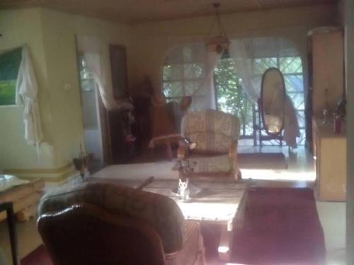 a living room with a couch and chairs and a table at Lovely 3-Bdrm Cottage w Private Patios Pkg Sanyang in Sanyang