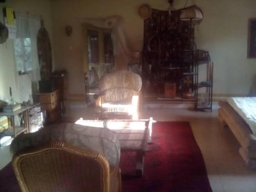 a living room with two chairs and a couch at Lovely 3-Bdrm Cottage w Private Patios Pkg Sanyang in Sanyang