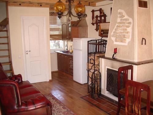 a living room with a fireplace and a kitchen at Adomo Rojus in Palanga