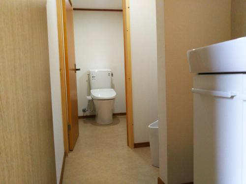 a small bathroom with a toilet in a room at ゲストハウス「古民家の宿梨本軒」 in Takayama