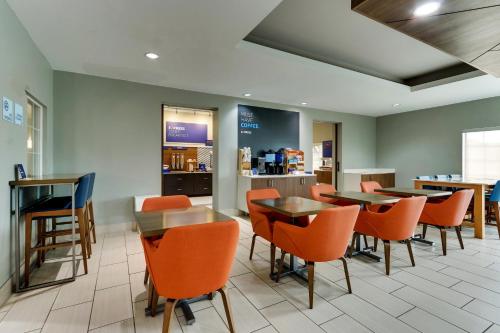 a restaurant with orange chairs and tables and a counter at Holiday Inn Express & Suites - Ardmore by IHG in Ardmore