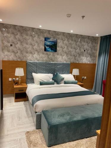 a bedroom with a large bed and two lamps at درة الينا للشقق المخدومة in Ar Rabwah