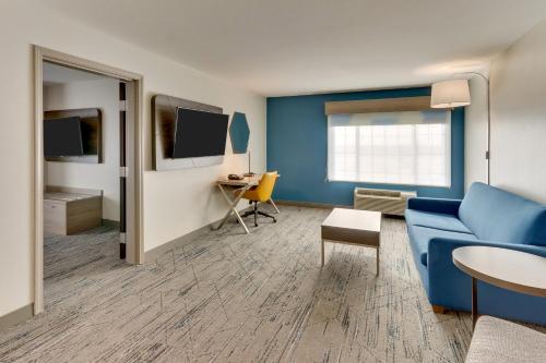 a living room with a blue couch and a table at Holiday Inn Express & Suites - Ardmore by IHG in Ardmore