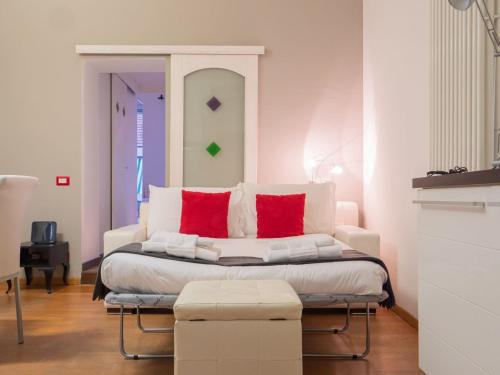 ein weißes Bett mit roten Kissen in einem Zimmer in der Unterkunft The Best Rent - Apartment near Navigli in Mailand