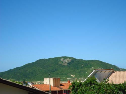 a mountain in the background with buildings and trees at Santinho Hostel in Florianópolis