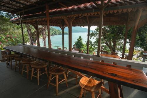 a long bar with stools and a view of the water at Legon Waru Cottage in Karimunjawa