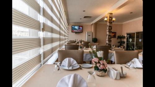 a dining room with tables and chairs and a television at kristal otel adana in Adana
