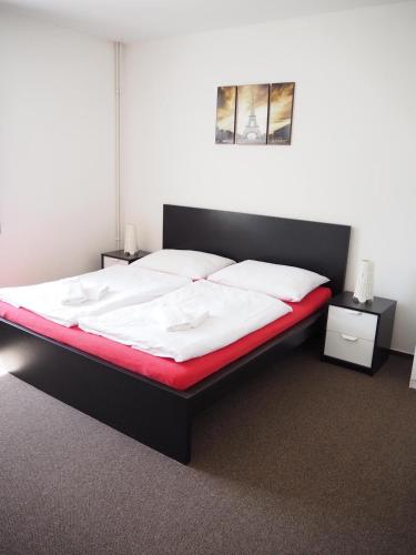 a bedroom with a bed with white sheets and red blanket at Penzion PANORAMA Janovičky in Broumov