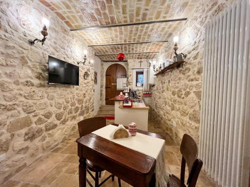 a dining room with a table and a stone wall at B&B Casa Antonetti in Campo di Giove