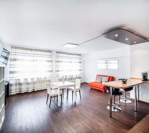 a living room with a table and chairs and a couch at BoardingWorld Heidelberg in Heidelberg
