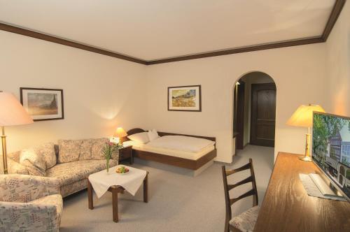 ein Wohnzimmer mit einem Sofa und einem Bett in der Unterkunft Häffner Bräu in Bad Rappenau