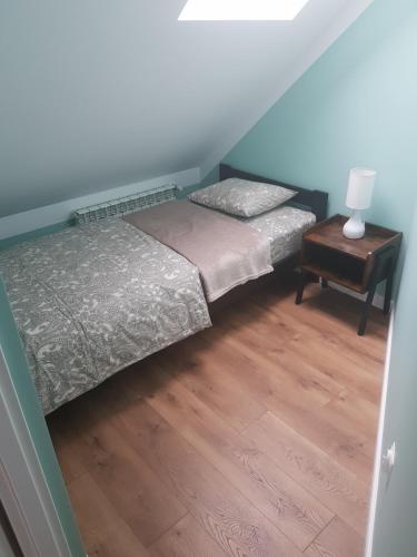 a bedroom with two beds and a night stand with a lamp at Apartamenty Tylicki Poranek in Tylicz