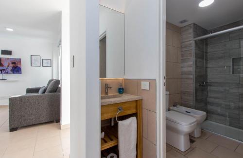 uma casa de banho com um WC, um lavatório e um chuveiro em Infinity Sky 2 em Ushuaia