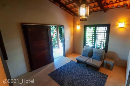 a room with a door and two chairs and a rug at 0031 Boutique Hotel & Restaurant Cumbuco in Cumbuco