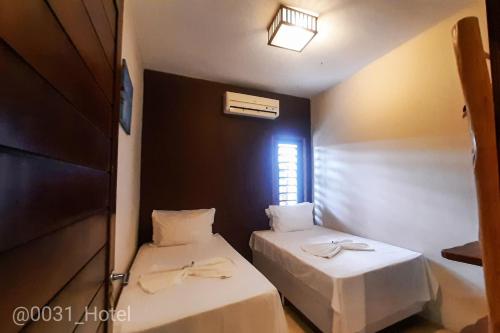 a room with two beds and a window at 0031 Boutique Hotel & Restaurant Cumbuco in Cumbuco