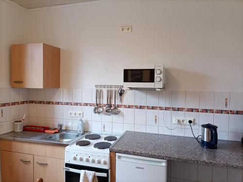 a kitchen with a stove and a sink at Hotel An der Karlstadt in Bremerhaven