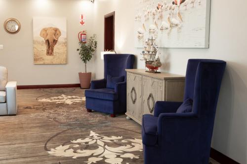 two blue chairs in a living room with an elephant at Flamingo Villas Boutique Hotel in Walvis Bay