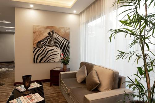 a living room with a couch and a painting of a zebra at Flamingo Villas Boutique Hotel in Walvis Bay